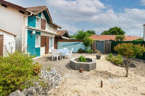 A house with a patio, a fire pit, and a small garden.