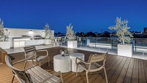 Terraza al aire libre con mobiliario, una zona de bar y plantas en macetas.