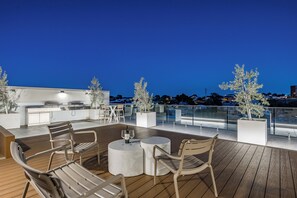 An outdoor deck with seating, a bar area, and potted plants. - Luxury Burswood Stay · Crown, Stadium & Swan River · Sleeps 6 (Burswood)