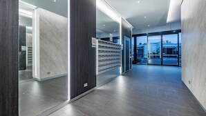 Un moderno vestíbulo de hotel con entrada de vidrio, una recepción y vistas al exterior.