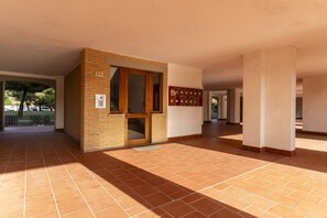 Un pasillo con suelo de baldosas, una puerta de madera y un buzón en la pared.