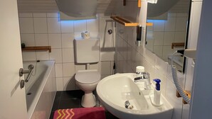 Ein Badezimmer mit Toilette, Waschbecken und Badewanne.