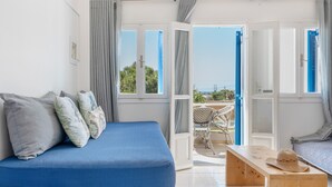 Una habitación con una cama, un banco de madera y vistas al exterior.