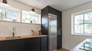 A modern kitchen with a stainless steel refrigerator, wooden countertop, and built-in cabinets. - Gamla Wallesvägen 10 - Bruksvallarna (Bruksvallarna)