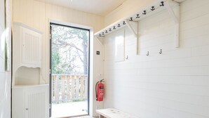A clean, modern room with a bench, a fire extinguisher, and a door leading outside. - Gamla Wallesvägen 10 - Bruksvallarna (Bruksvallarna)
