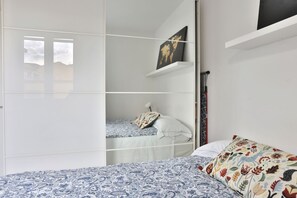 A bedroom with a bed, a wardrobe, a shelf with a picture, and a window. - GuestHost - Florence Modern & Quiet Nest (Firenze)