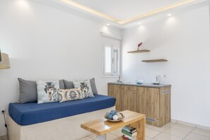 Un salon moderne avec un canapé, un meuble en bois et une petite table sur laquelle sont posés des livres.