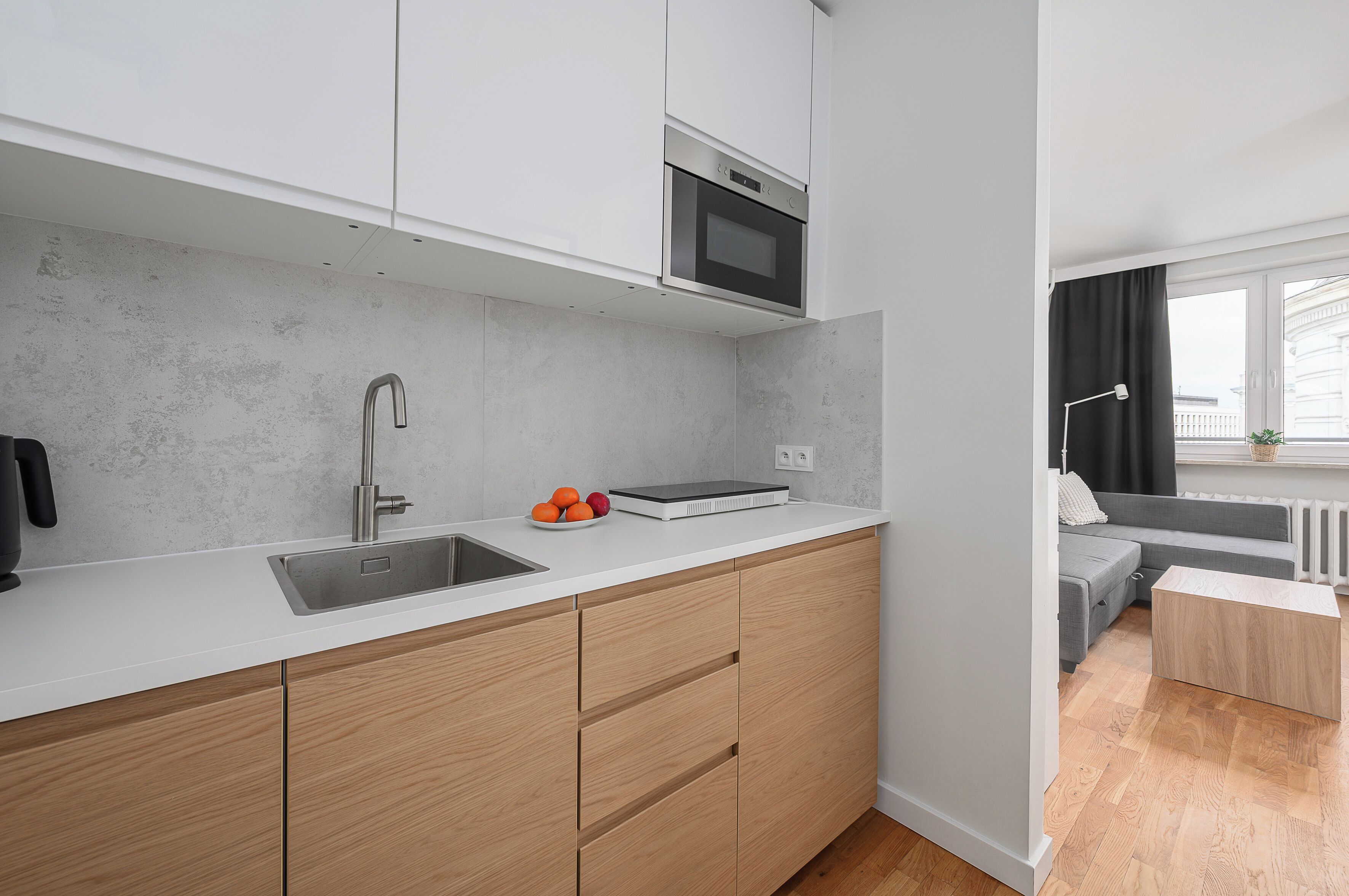 Une cuisine moderne équipée d’un four encastré, d’un évier et d’un plan de travail.