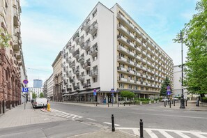 Ein mehrstöckiges Hotel mit Balkonen, einem Parkschild und einer Fußgängerampel.