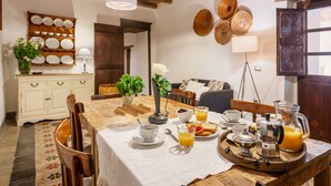 A dining table with breakfast items, a coffee maker, and a fruit pitcher. - Bissantica, 17th-Century Stone House - Authentic Sardinia, Private Courtyard (Lunamatrona)
