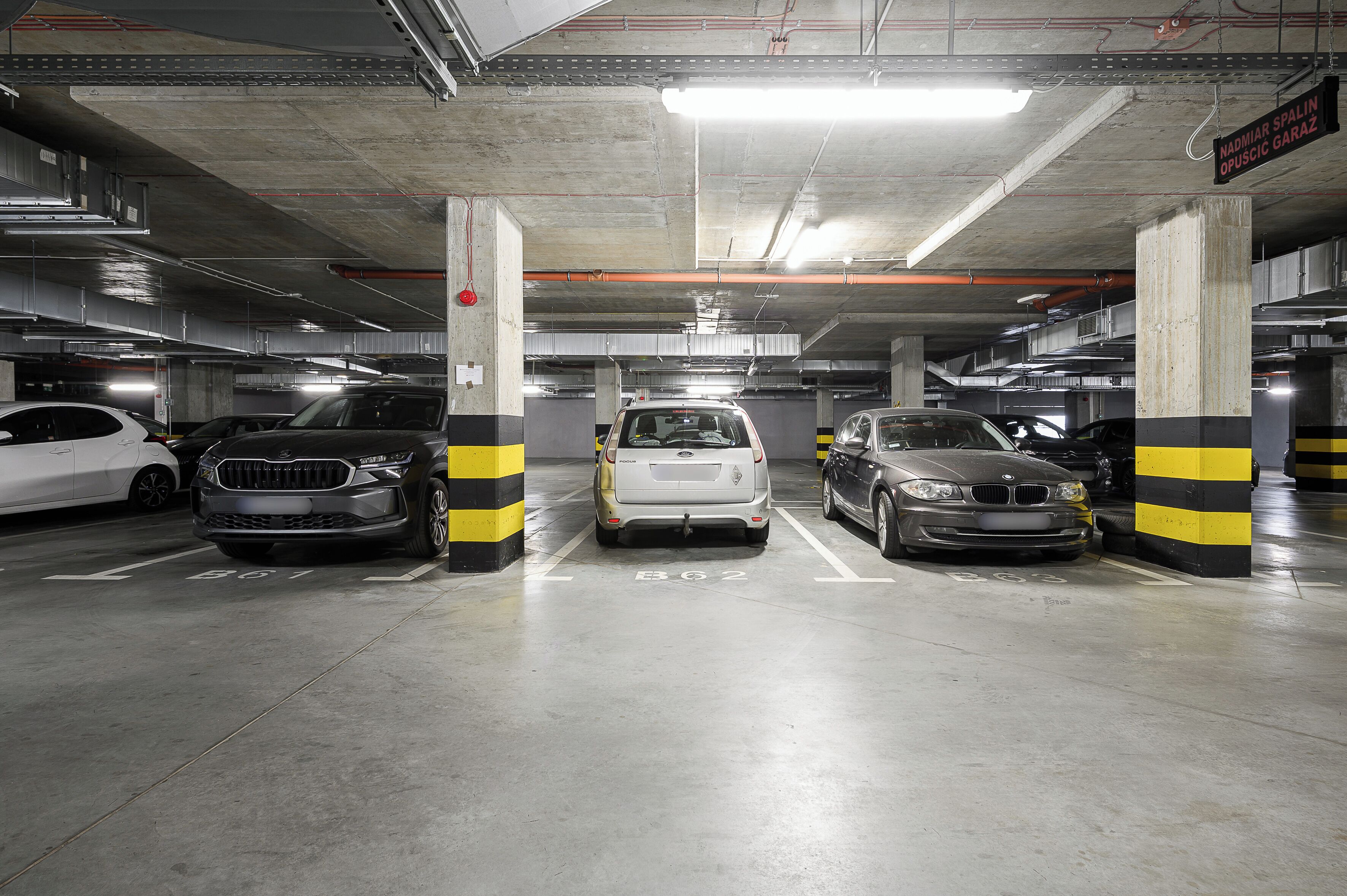 A multi-level parking garage with concrete pillars and marked parking spaces.