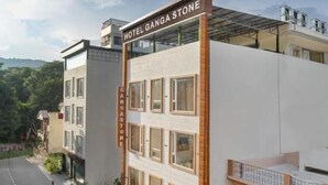 Un edificio de varios pisos con un letrero que dice 'HOTEL GANGA STONE'.