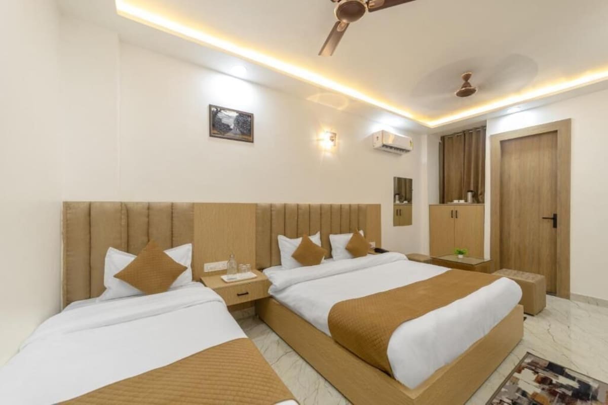 A hotel room with a large bed, bedside tables, a ceiling fan, and a wardrobe.