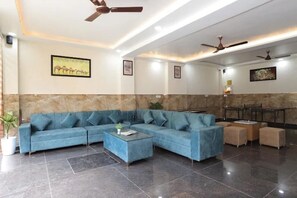 Uma sala de estar moderna com um sofá seccional, uma mesa de centro e uma área de jantar com cadeiras.