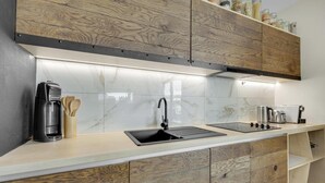 Une cuisine moderne dotée d’une cuisinière intégrée, d’un évier et d’armoires en bois.