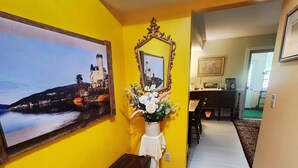 Ein Flur mit einer Bank, einem Spiegel und einer Blumenvase.