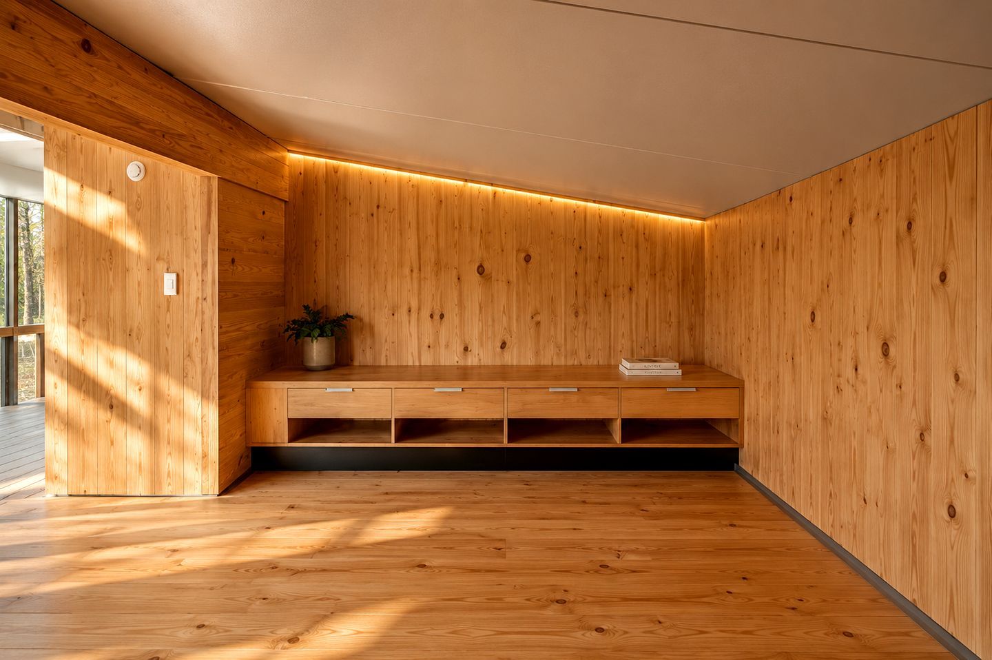 Una habitación con paredes de madera y un banco con cajones.