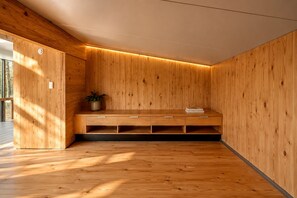 A room with wooden walls and a bench with drawers. - Serene Modern Tiny Home with Fiery Gizzard Reservoir Views Near Tracy City | Tennessee (Tracy City)
