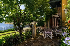 Une terrasse dotée d’un sol en pierre, de rampes en métal et de mobilier d’extérieur.