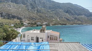 A coastal building with a view of the sea and mountains.