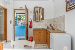 A compact kitchen with a sink, a small refrigerator, and a window with a view of the outdoors. - Katerina's Studio '1' with Sea View and Private Balcony (Arginonta)