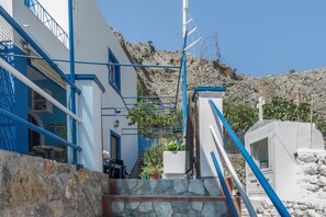 A stone staircase leading to a white building with blue accents, a view of a rocky hillside, and a clear blue sky. - Katerina's Studio '2' with Sea View and Private Balcony (Arginonta)