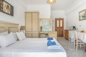 A hotel room with a bed, a desk, a chair, a small kitchenette, and a window with a view. - Katerina's Studio '2' with Sea View and Private Balcony (Arginonta)
