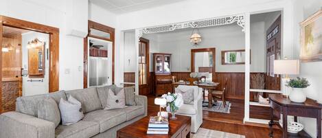 Una sala de estar con sofá, mesa de centro y un comedor con mesa y sillas.