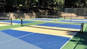 An outdoor tennis court with a net, surrounded by a fence and trees. - Enjoyable Cabin with Fireplace and Foosball in Twain Harte, California (Twain Harte)