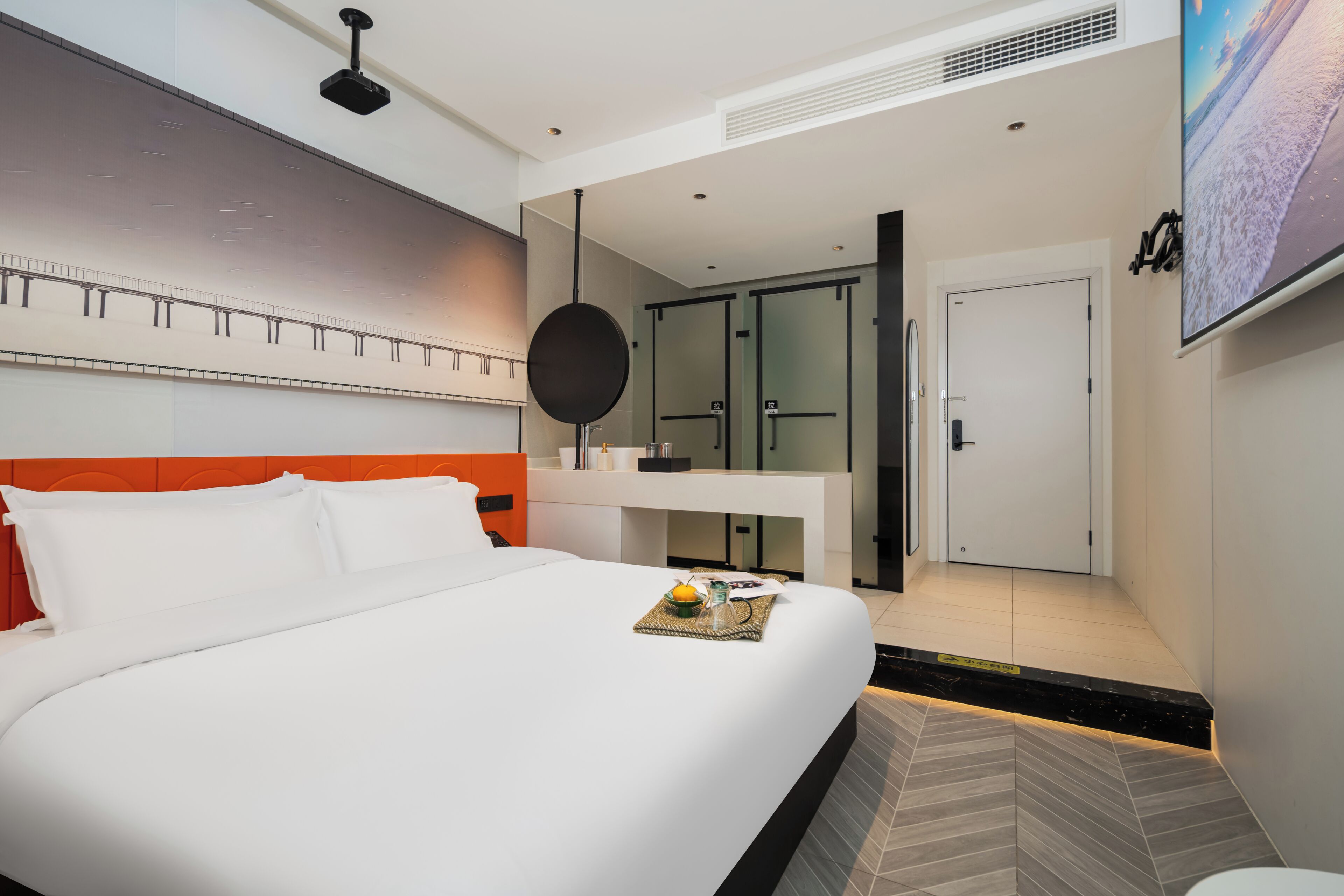 A modern hotel room with a large bed, a desk, and a TV.