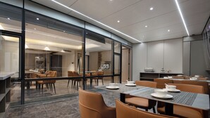 A modern dining area with glass walls, tables with white plates, and brown chairs. - Key View Hotel (Chongqing)