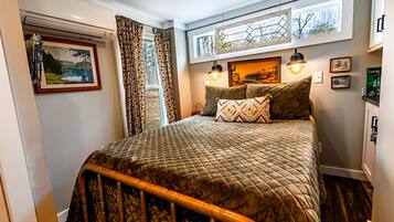 Un dormitorio con cama, cortinas, decoración en la pared y ventana.
