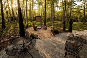 Un patio con un brasero, asientos y un cobertizo pequeño.