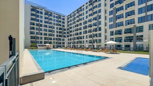Ein modernes Gebäude mit Swimmingpool und Liegestühlen.