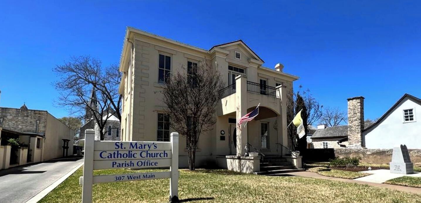 A two-story building with a sign indicating it is St. Mary's Catholic Church Parish Office.
