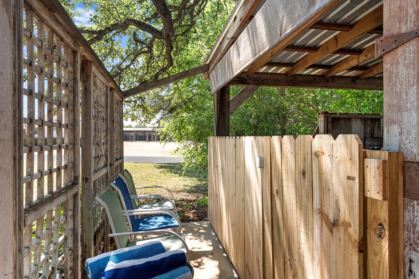 Un espace extérieur abrité, avec une clôture en bois et des chaises.
