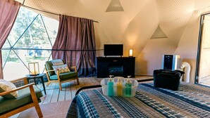 A tent-style room with a bed, seating area, television, and a fireplace. - Whimsical Dome Escape Amid the Majestic Mountains and Enchanting Rivers of New York (Gilboa)