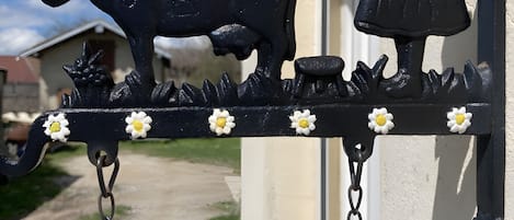 En svart metallskylt med en ko och en flicka, och ordet ”Bienvenidos” på en byggnad.
