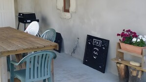 A rustic outdoor seating area with a wooden table and chairs, a chalkboard with numbers, and a planter with flowers. - Holiday Home "Gîte Des 4 Lacs" with Mountain View, Private Terrace and Wi-Fi (Vertamboz)