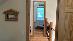A wooden staircase leading to a bedroom with a bed and a window. - Amazing hilltop views of gorgeous Sage Lake with beach and boat launch access. (Hale)