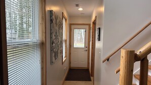 A hallway with a wooden staircase, a door, and a window with blinds. - Amazing hilltop views of gorgeous Sage Lake with beach and boat launch access. (Hale)