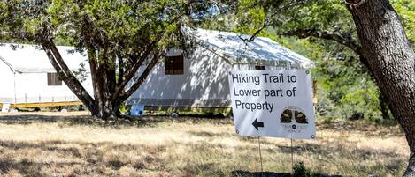 A sign indicating a hiking trail to the lower part of a property.
