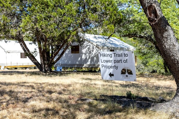 A sign indicating a hiking trail to the lower part of a property.