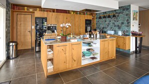 Una cucina moderna con pensili in legno, forno integrato e schienale rivestito di piastrelle.