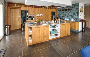 Eine moderne Küche mit Holzschränken, einem eingebauten Backofen und einer gefliesten Rückwand.