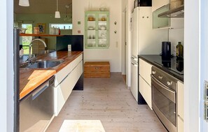 A kitchen with wooden countertops, stainless steel appliances, and a green cabinet. - Amazing home in Stege with sauna (Stege)