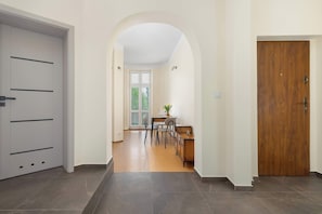 Ein Flur mit Essbereich, einer Holztür und einer weißen Wand.