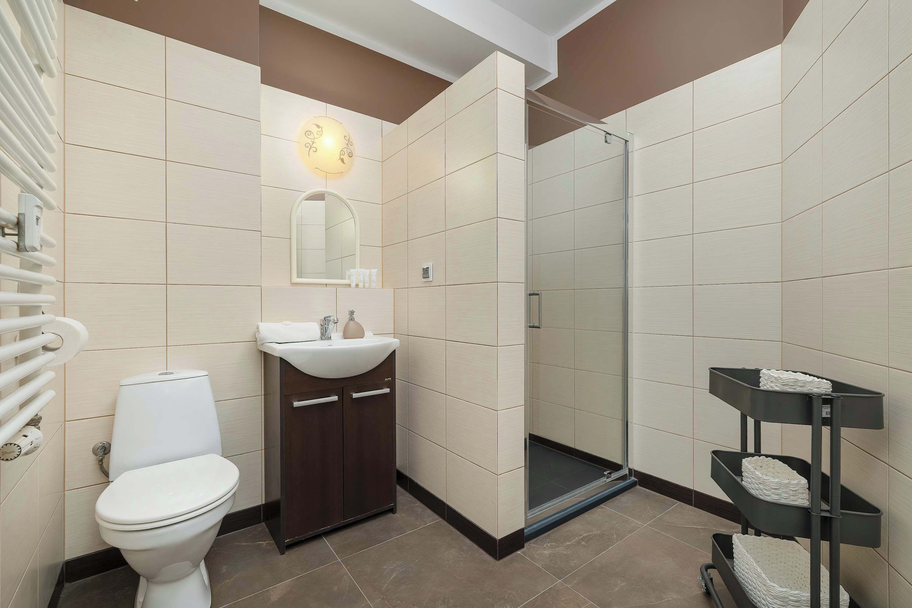 Un baño con inodoro, lavabo, espejo y zona de ducha.