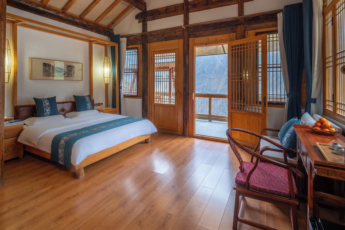 A wooden-framed room with a bed, a desk, and a chair.