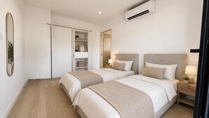 A bedroom with two beds, a wardrobe, a mirror, an air conditioner, and bedside lamps. - Beautiful 4-bedroom detached villa—with private pool and garage, fully equipped, near the ocean (Santa-Lucia-di-Moriani)
